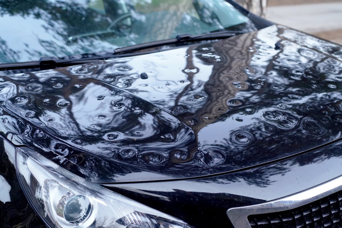 Hageldellen auf dem Dach eines Autos im Streiflicht, Grundlage für die Bewertung eines Hagelschadens in der Teilkasko